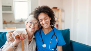 image of a senior adult hugging and smiling with her caregiver